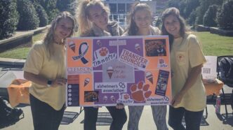 A group of four women hold a sign
