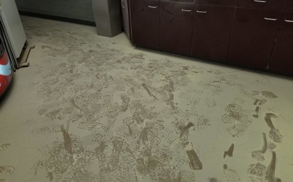 A trail of footprints in a kitchen area covered with fire extinguisher powder.