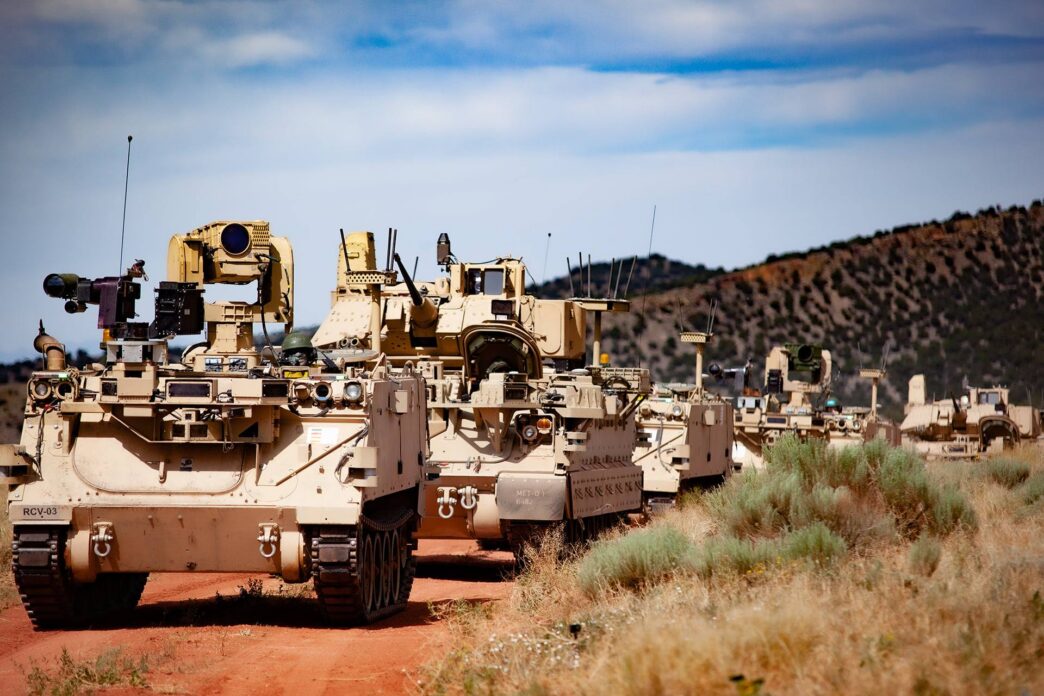 Image of military vehicles driving on dirt roads.