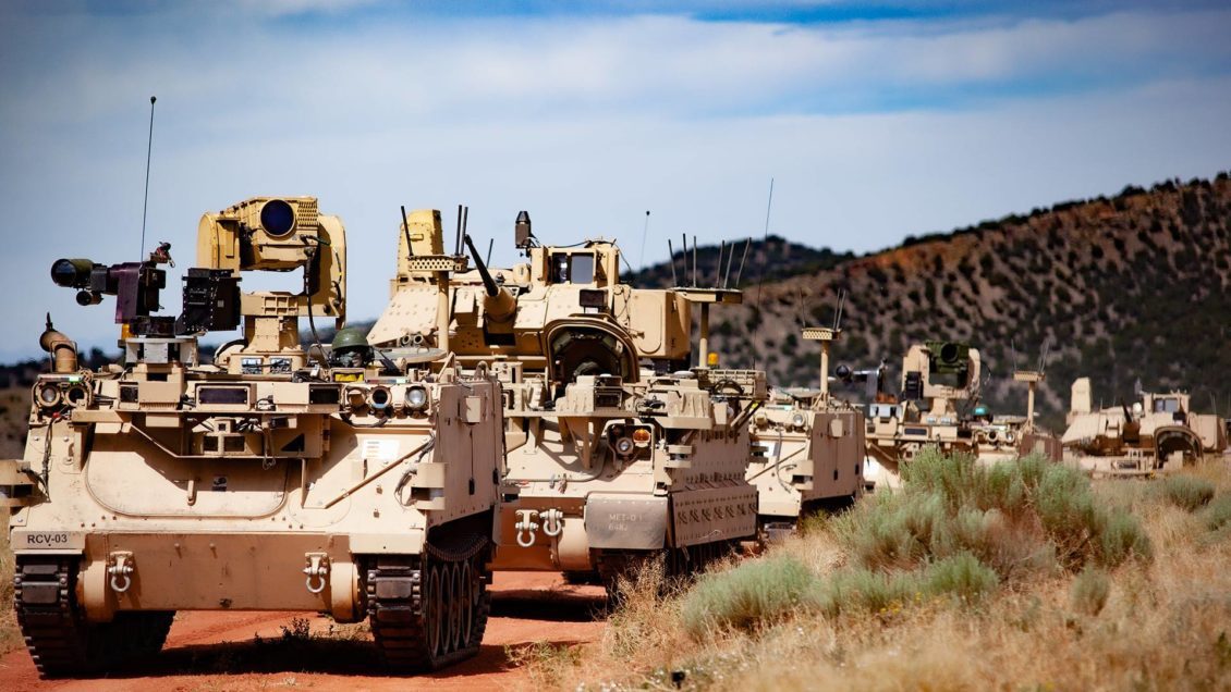 Image of military vehicles driving on dirt roads.