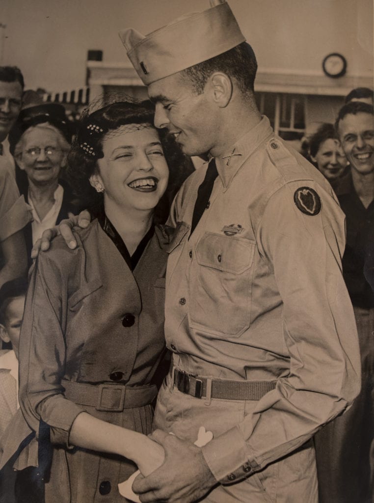 Black and white photo of a young Bill Funchess in uniform embracing his wife