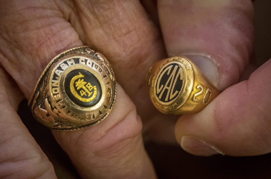 Close up of hands holding two Clemson class rings