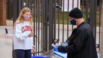 A student participates in COVID-19 testing at Memorial Stadium