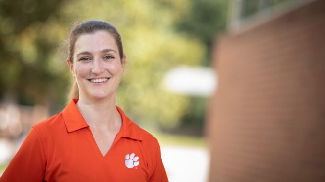 Image of woman in orange shirt with tiger paw.