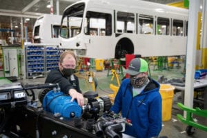 Two men work in electrical bus manufacturing plant