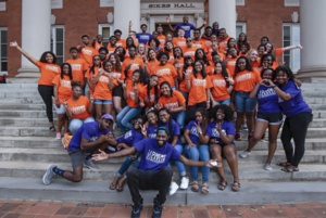 A large group of African American students pose on the steps of Sikes Hall