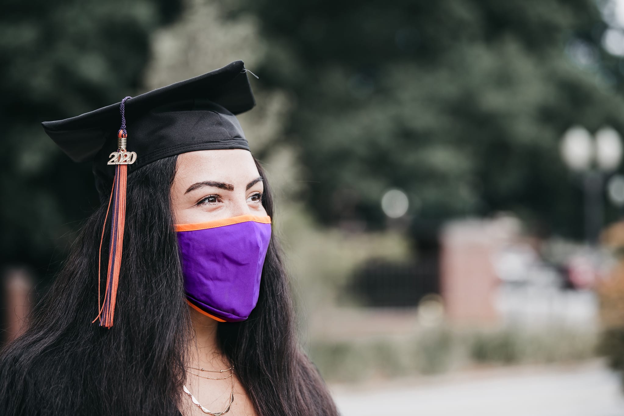 Female student in graduation hat and facemark