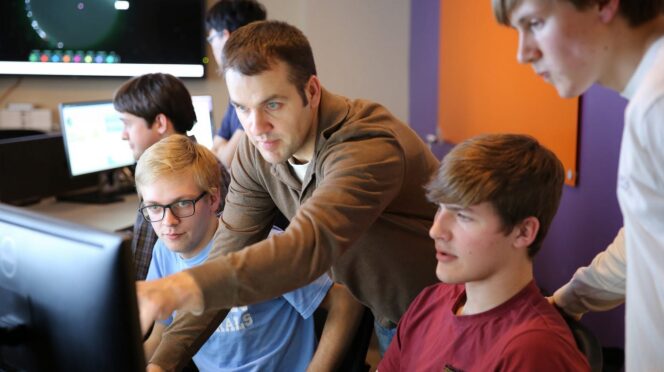 John Hoyt points out some of the center’s network security features to Zach Whitworth, Grant Adams and Carson Sallis.