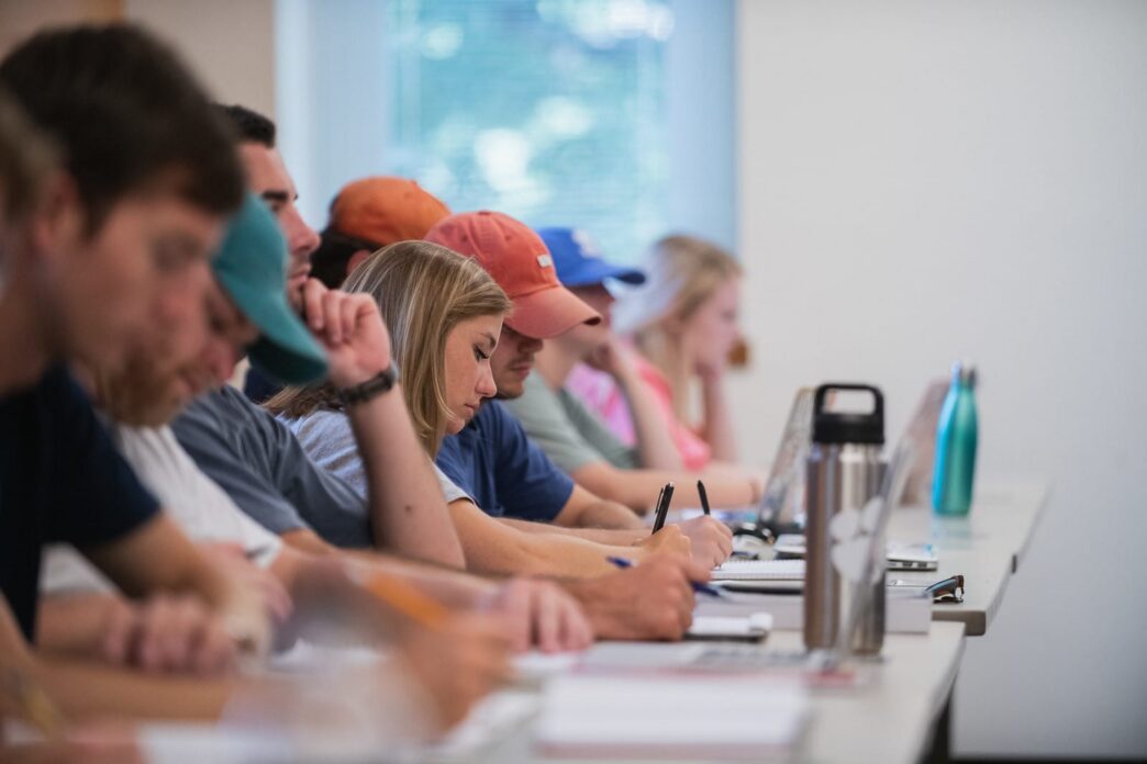 Row of students at long table working