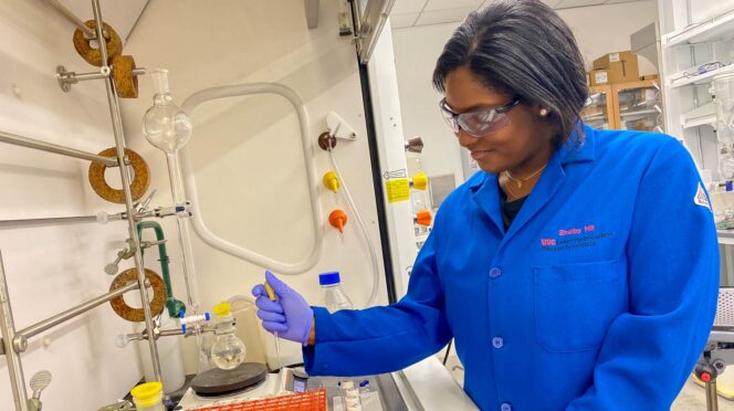 a woman in a lab coat works in a science lab