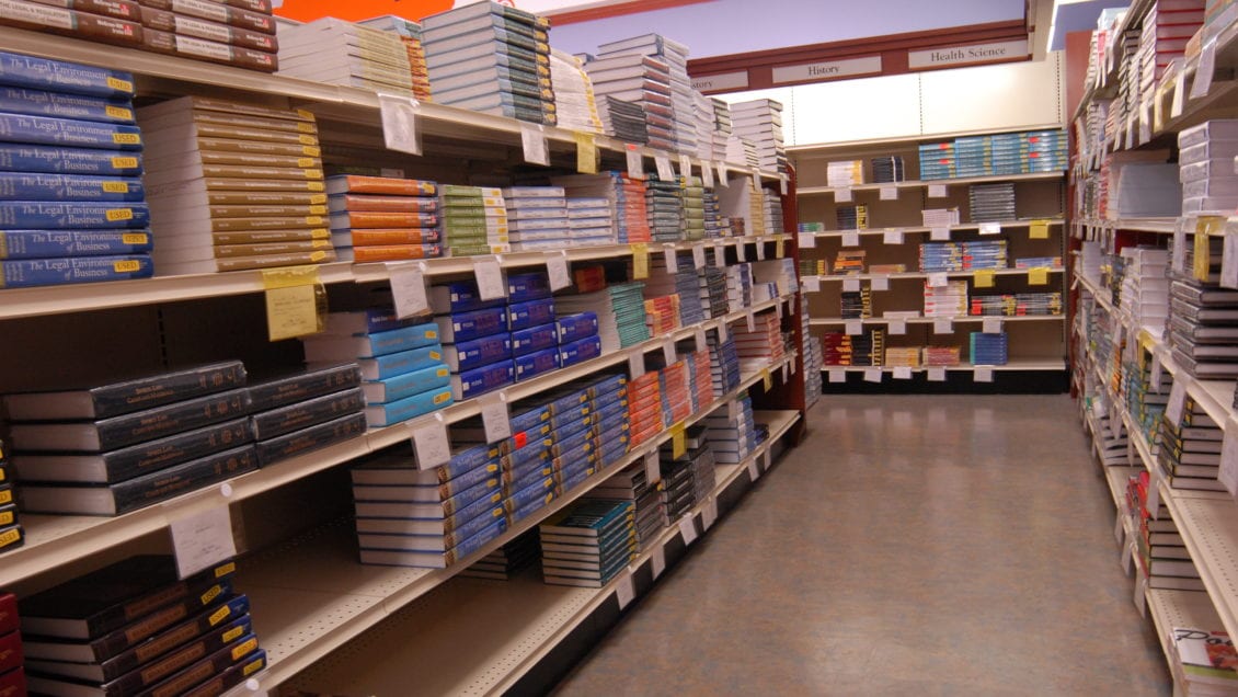 A long, high row of textbooks in a store.