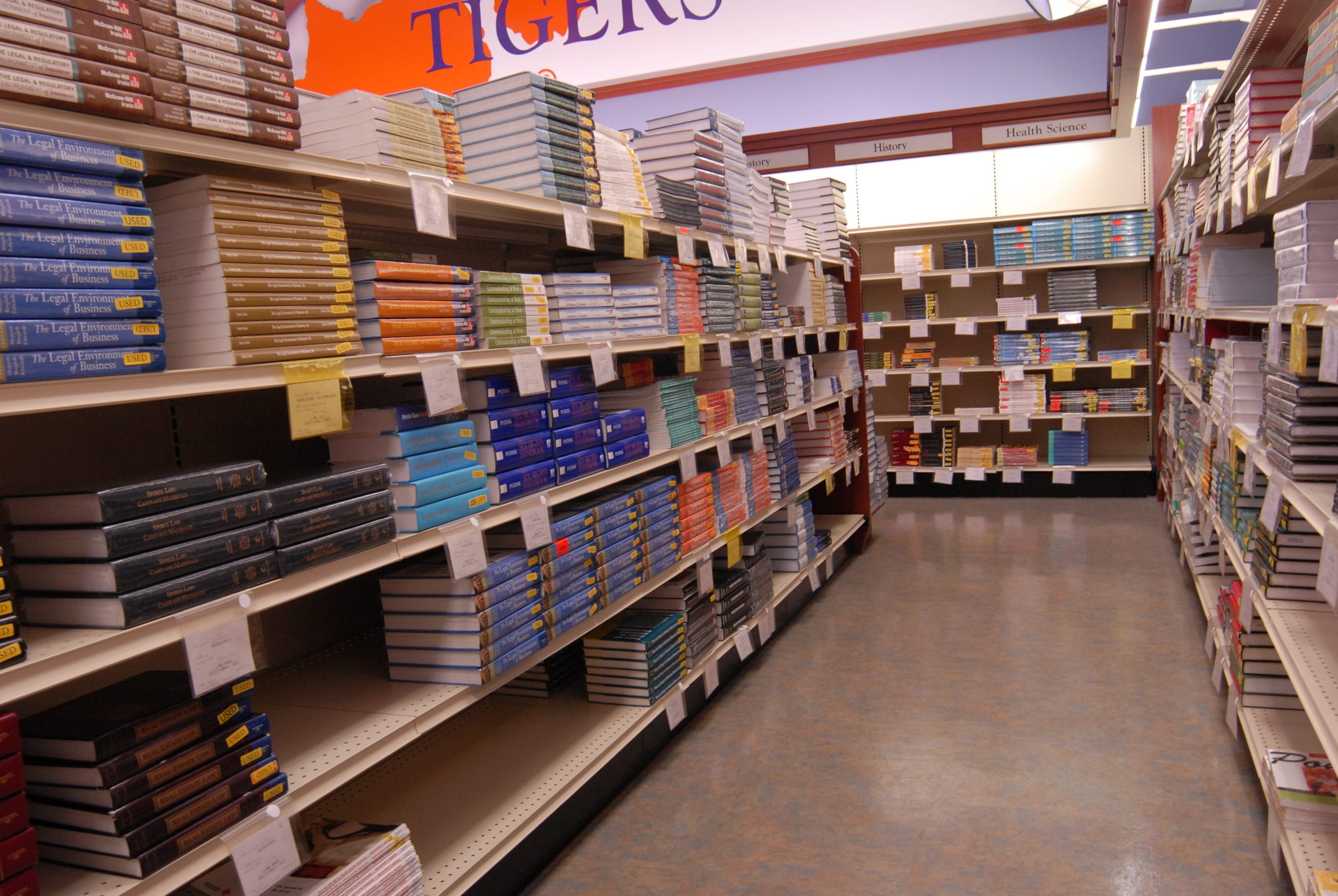A long, high row of textbooks in a store.