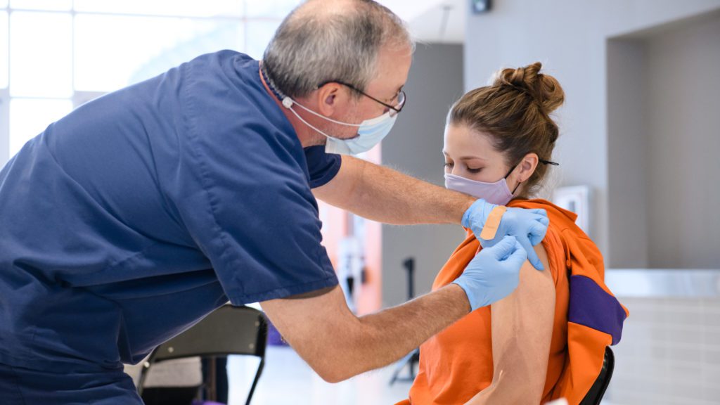 A student athletic trainer receives a COVID vaccine in January 2021