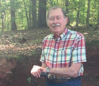 Bill Smith stands in a dirt pit.