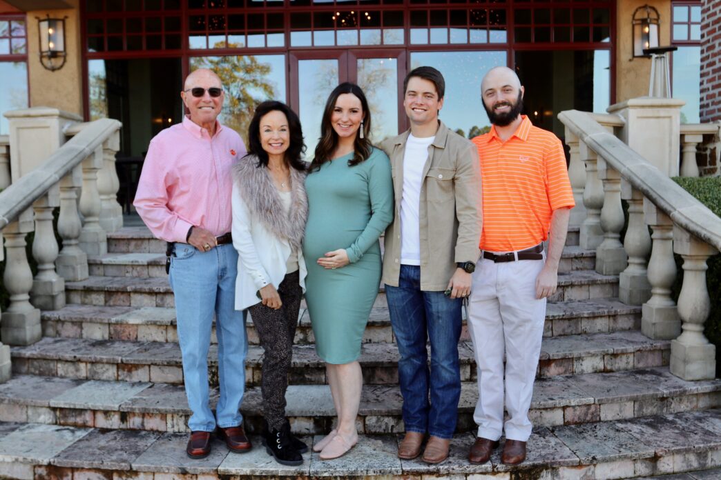 An outdoor portrait of the Glenn family standing on steps outside a home.
