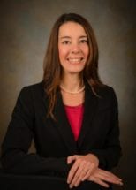 Professional photo of Chief Ethics and Compliance Officer & Associate Vice President Tracy Arwood smiling and dressed in a dark, single breasted suit.