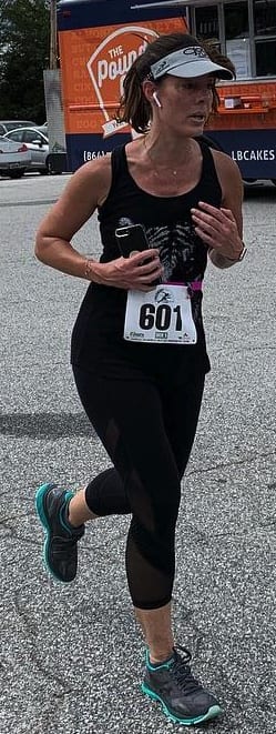 A runner with earbuds in and a race bib number.