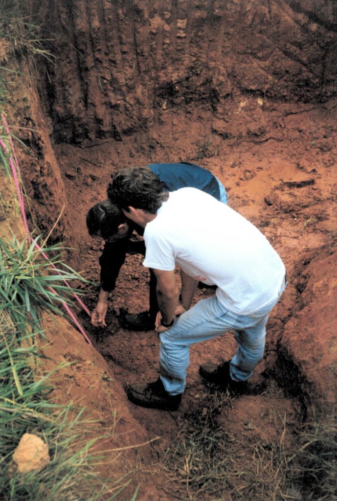 Clemson soil professor gets in a soil pit to teach soil properties to a student.