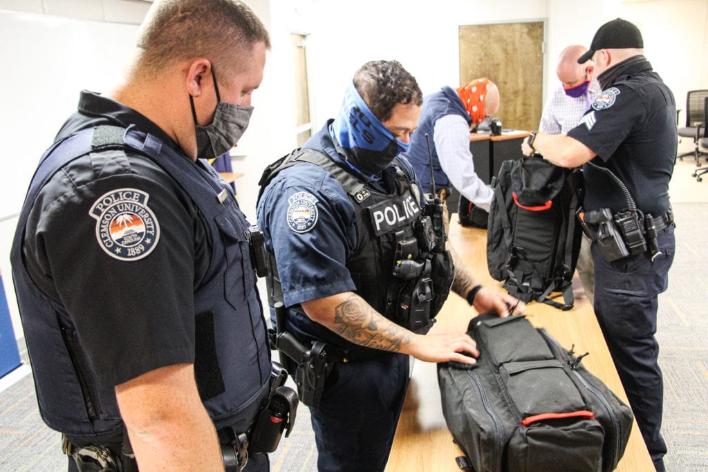 Steven Cannon and Omar Arredondo of Clemson University Police Department look through a backpack from TacMed Solutions, which includes donated trauma kits designed to help enhance campus safety