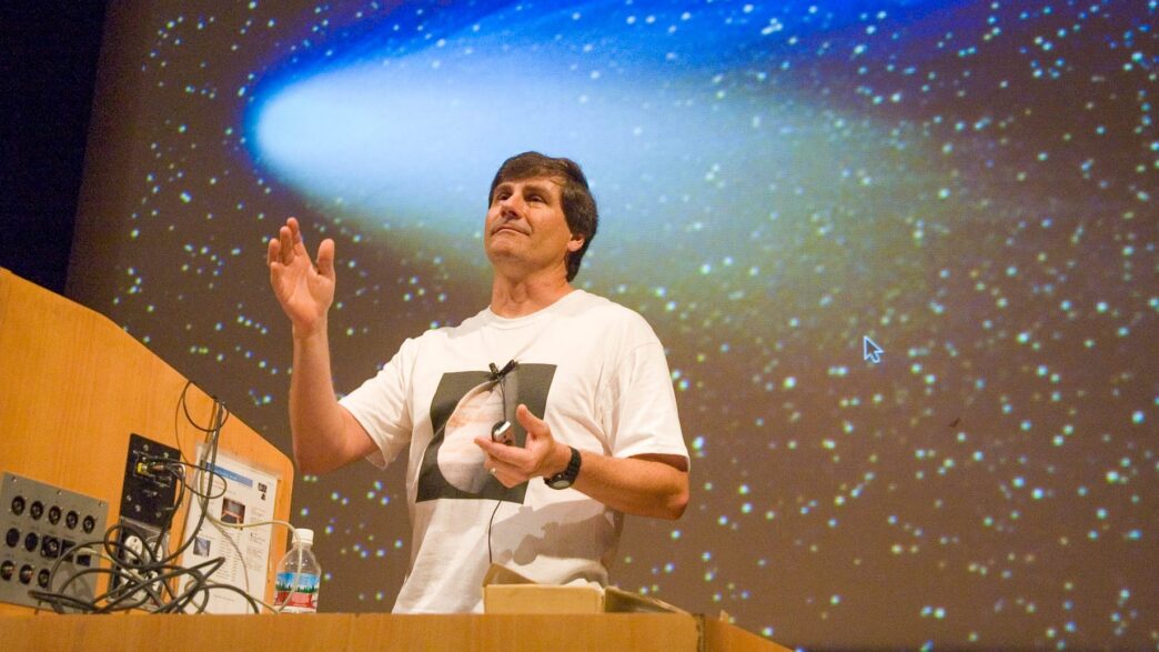man standing at podium with stars in the background