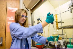 woman wearing blue lab coat working in a lab