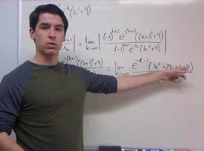 Man pointing to an equation on a white board