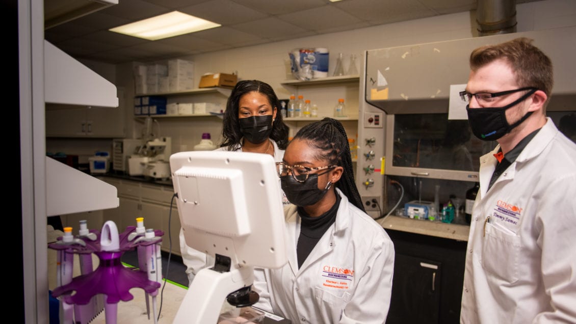 Angela Alexander-Bryant (left) works in her lab with Kharimat Lora Alatise (center) and Timmy Samec.
