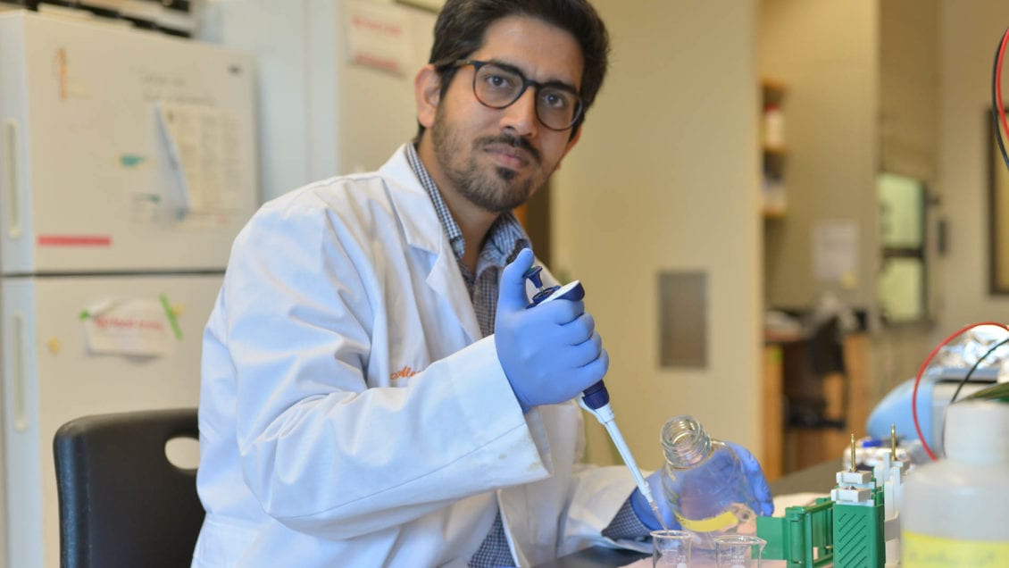 man wearing white lab coat in lab