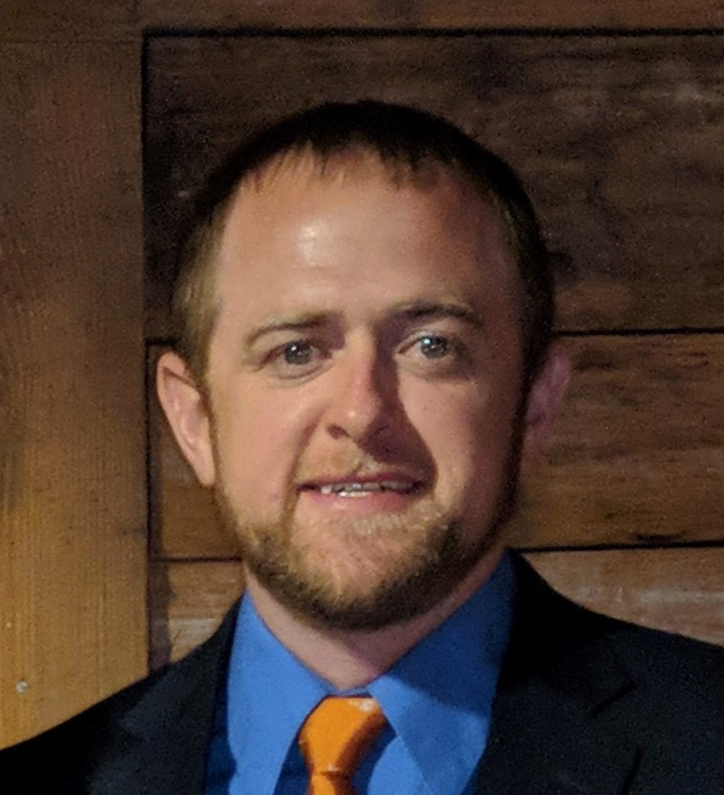 Headshot of Steve Long in blue blazed and orange tie.