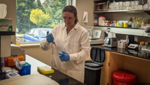 Woman wearing white lab coat working in a science lab
