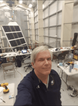 Man standing in a lab in front of a solar panel