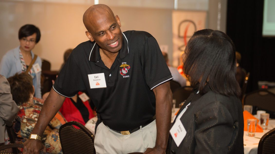 Carl Sharperson engages with an attendee at the 2014 Emerging Scholars reception