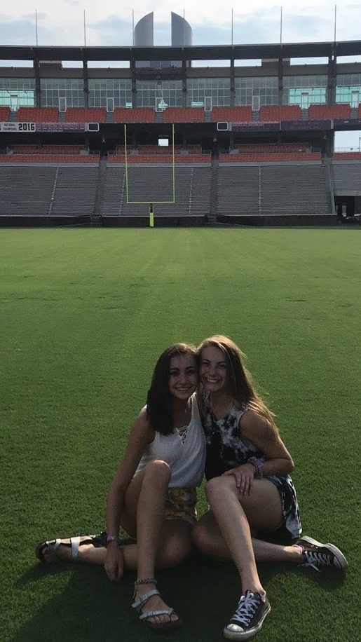 two college students sitting on the football field in Death Valley, Clemson