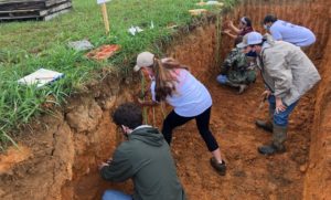 Clemson student Devon Griffin picks the soil profile in a pit during the Southeast Regional Collegiate Soils Contest in Knoxville, Tennessee.