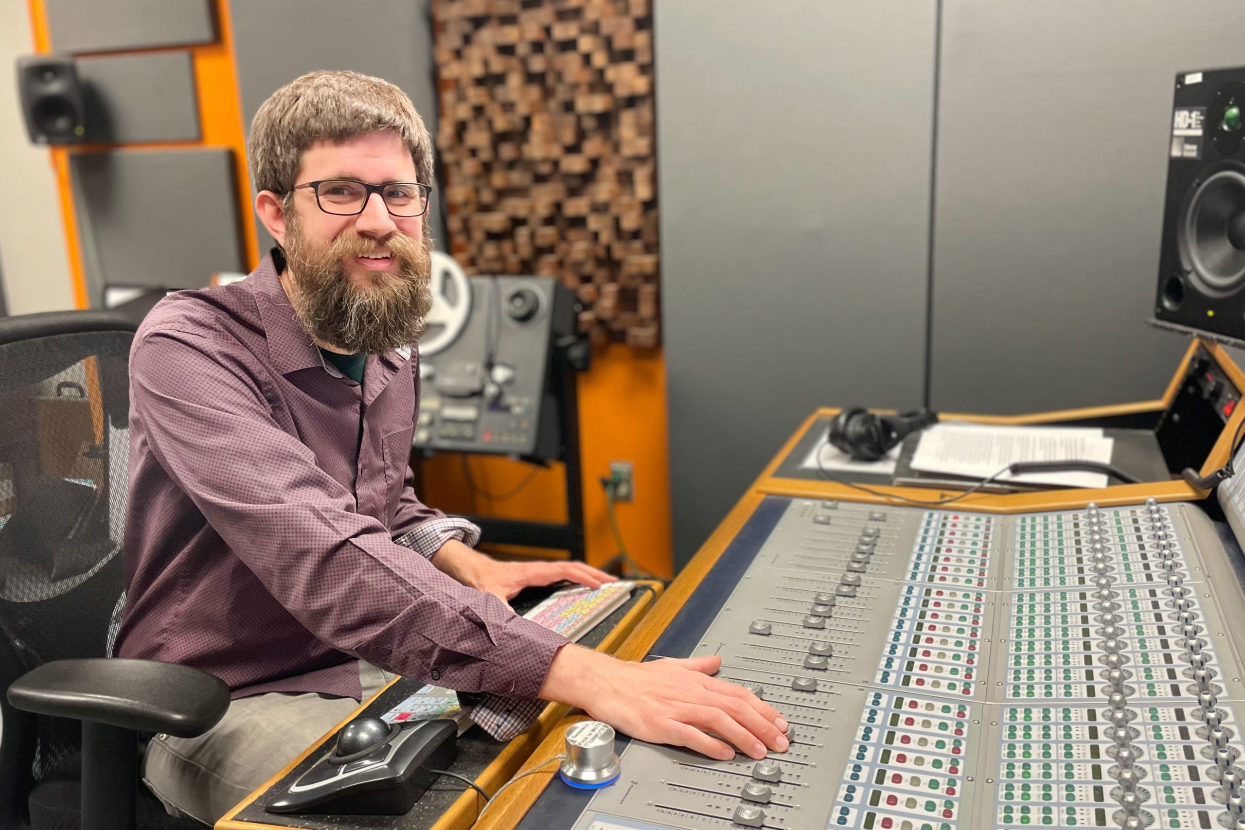 Dewey Boyd sits at an audio control board in Brooks Center for the Performing Arts