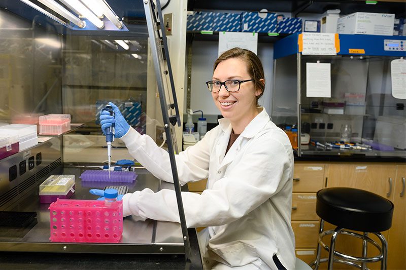 Jessica Deaver sits at a workbench in the lab.