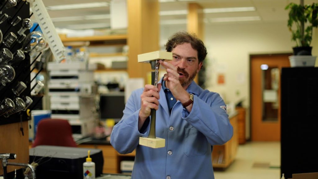Clemson professor Jeff Anker holds a replica of a tibia bone that has had a plate attached to help fix a break.