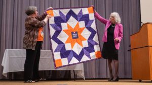 Victoria Ridgeway Gillis presents a quilt to Executive Director Debra Jackson