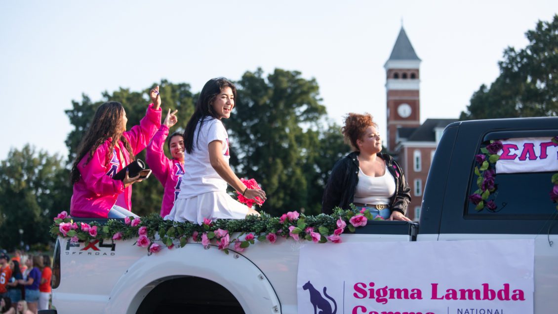 Members of Sigma Lambda Gamma sorority ride in the First Friday Parade in September 2021