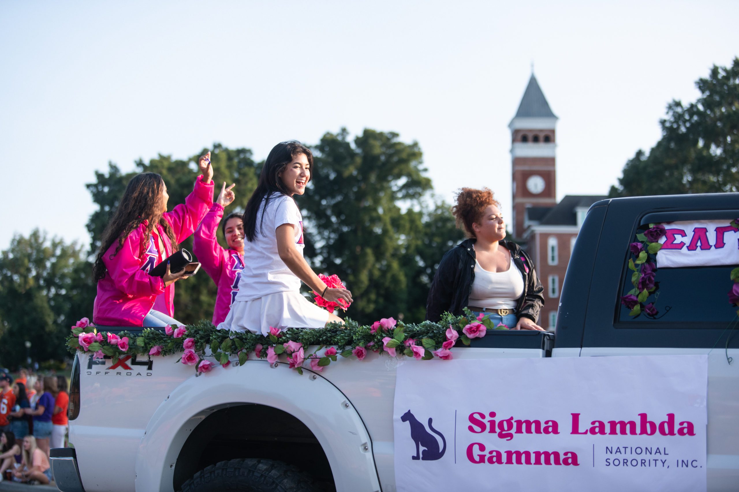 Members of Sigma Lambda Gamma sorority ride in the First Friday Parade in September 2021