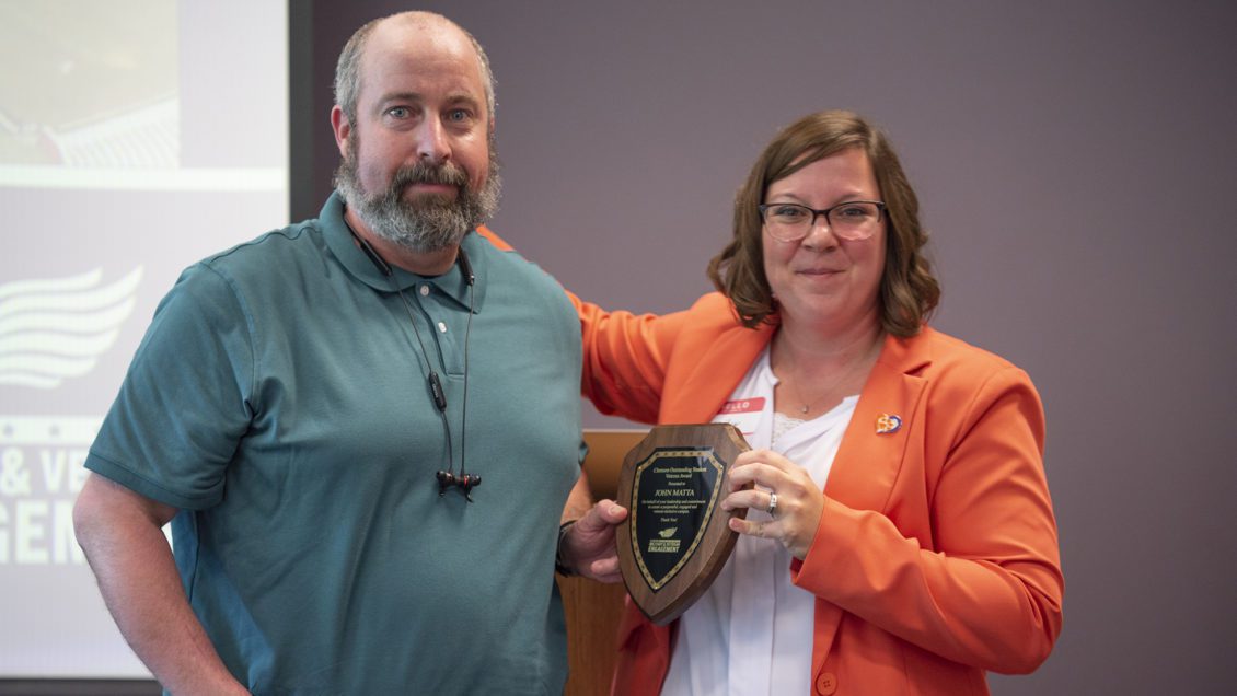 John Matta receives the Outstanding Student Veteran Award from Director of Military and Veteran Engagement Emily DaBruzzi in May 2022