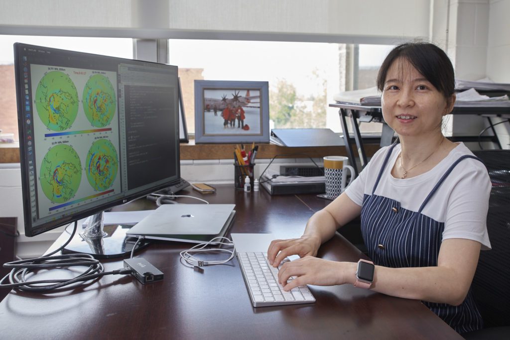 Clemson University Physics Associate Professor Xian Lu sits at the computer
