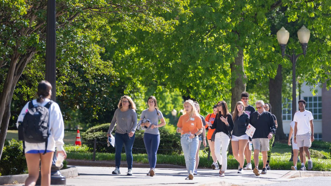 Students walking outside, speaking with one another as they walk. Spring 2022 dean's list