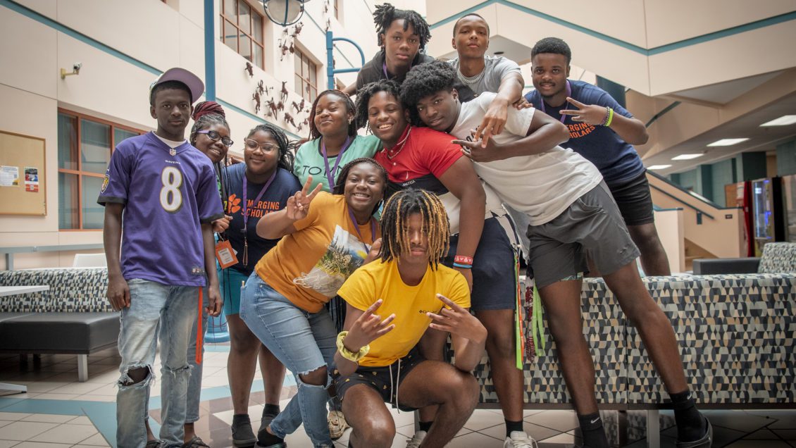 A group of high school Emerging Scholar students pose for the camera inside a Clemson University academic building.