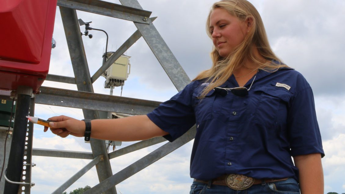 Shelley Lovern, Clemson master's student, tests a center pivot irrigation system at the Simpson REC with a voltmeter.