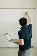 Yao Wang writes something on a whiteboard
