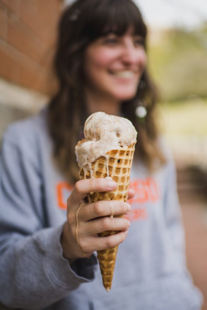 A female student holds an ice cream cone.
