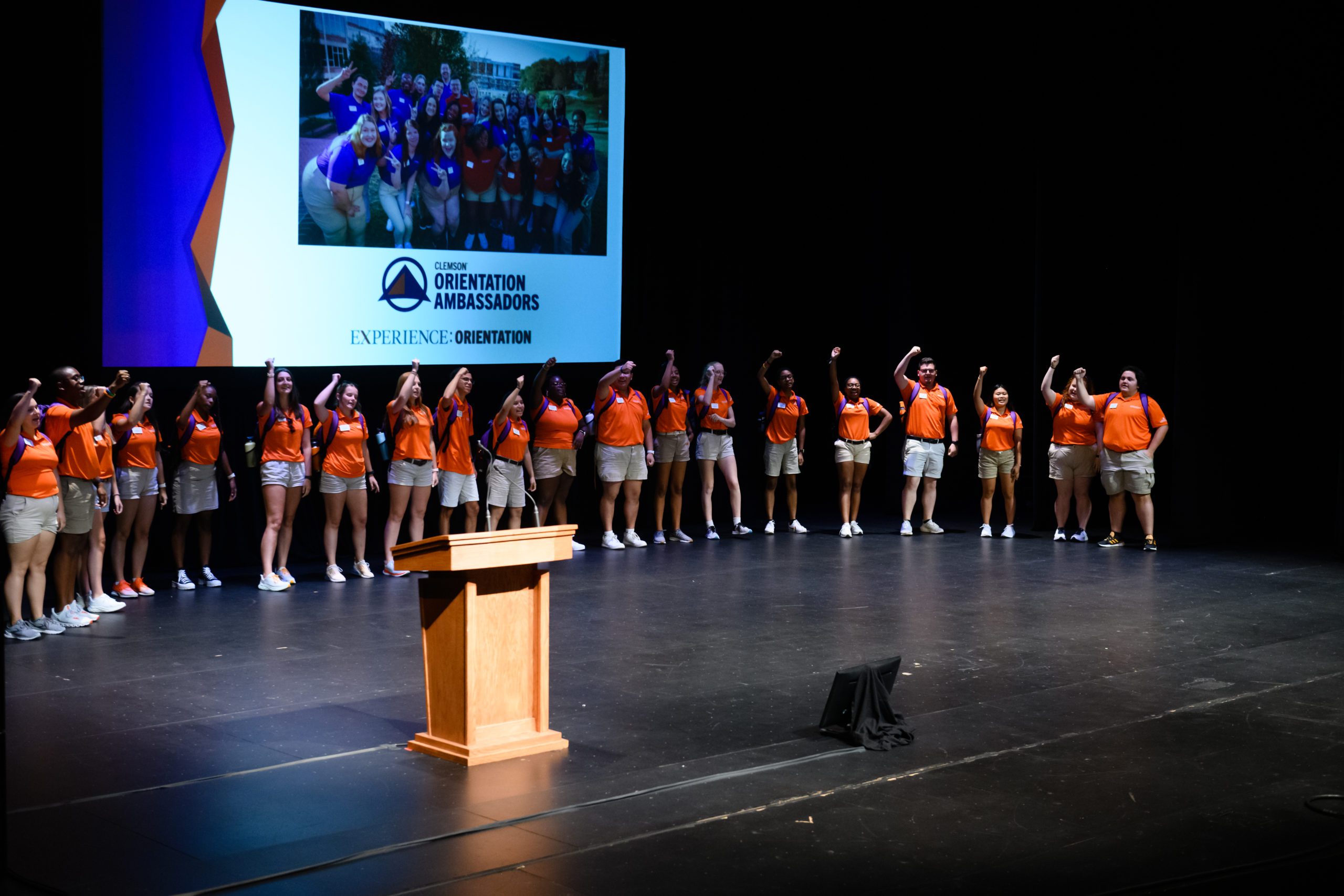 A group of Orientation Ambassadors stand on stage.