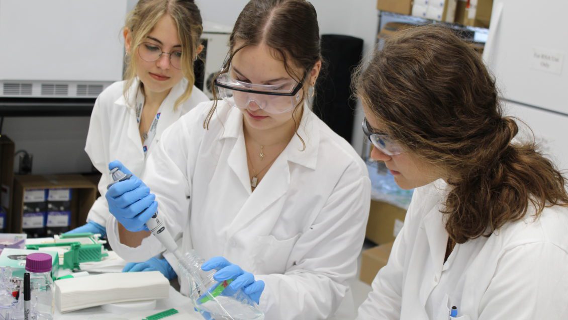 A group of three female high school scholars from Germany studying in the Clemson research Sachin Rustgi's lab.