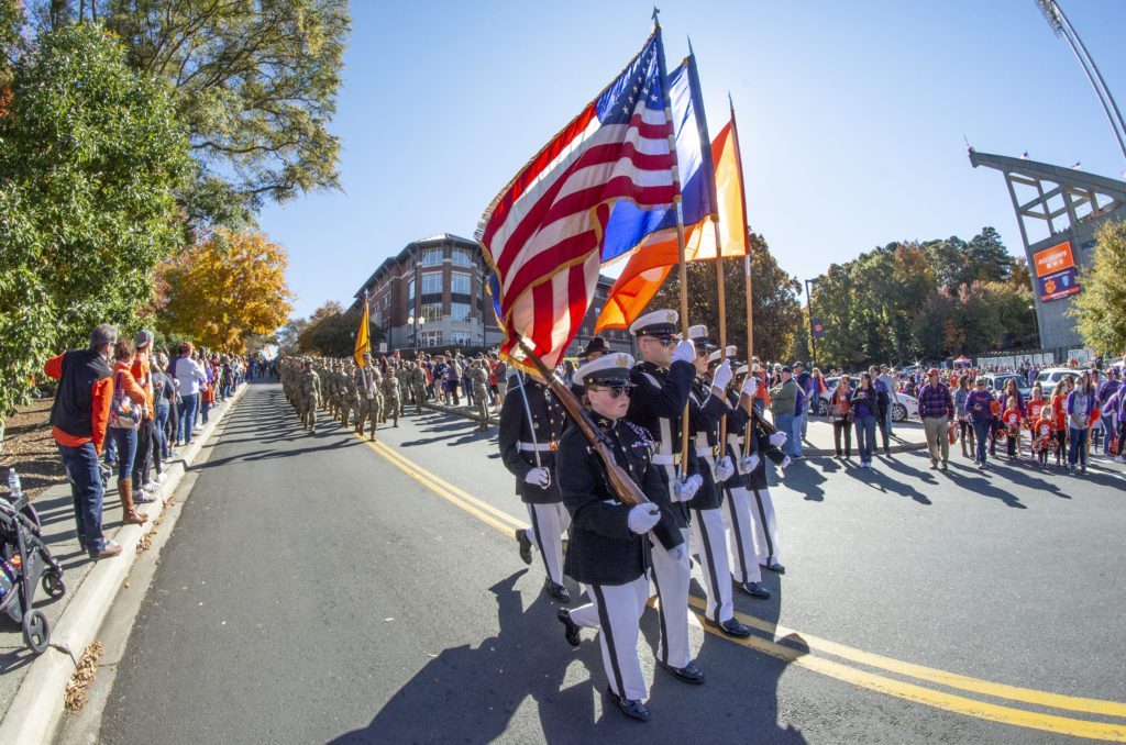 Members of the Pershing Rifles honor guard lead ROTC cadets down the hill toward Memorial Stadium